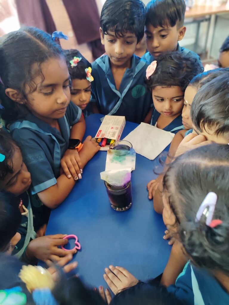 Children gathered around a hands-on classroom experiment at Yen’s World School